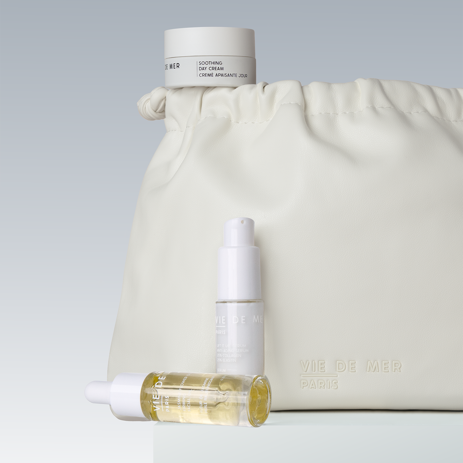 Skincare products with a cream-colored drawstring bag on a light gray background