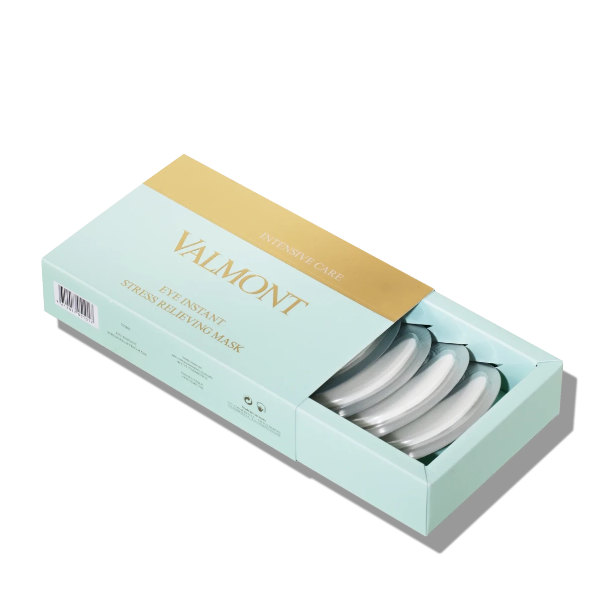 Valmont Eye Instant Stress Relieving Mask in a light mint green box with a gold accent band, shown open with several round white masks inside on a white background.