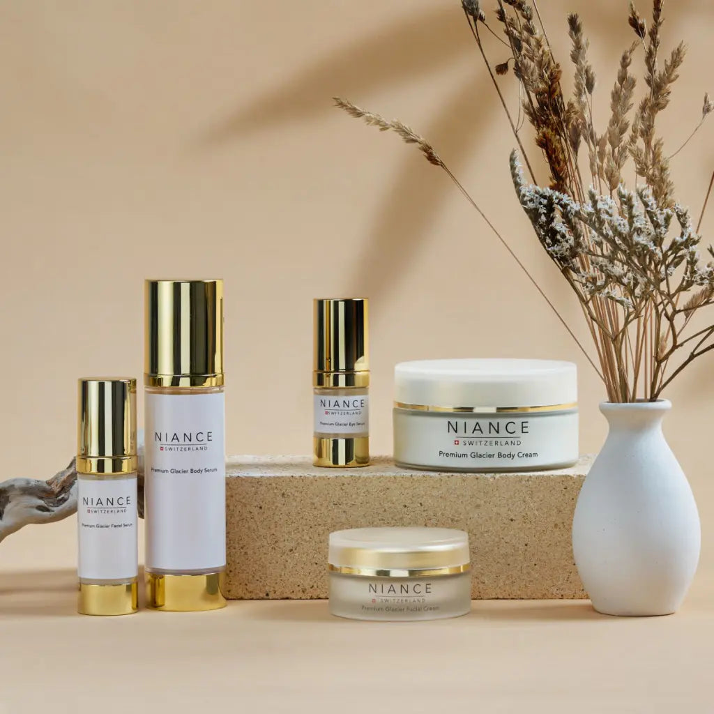 NIANCE skincare products on a beige background with a vase of dried flowers.