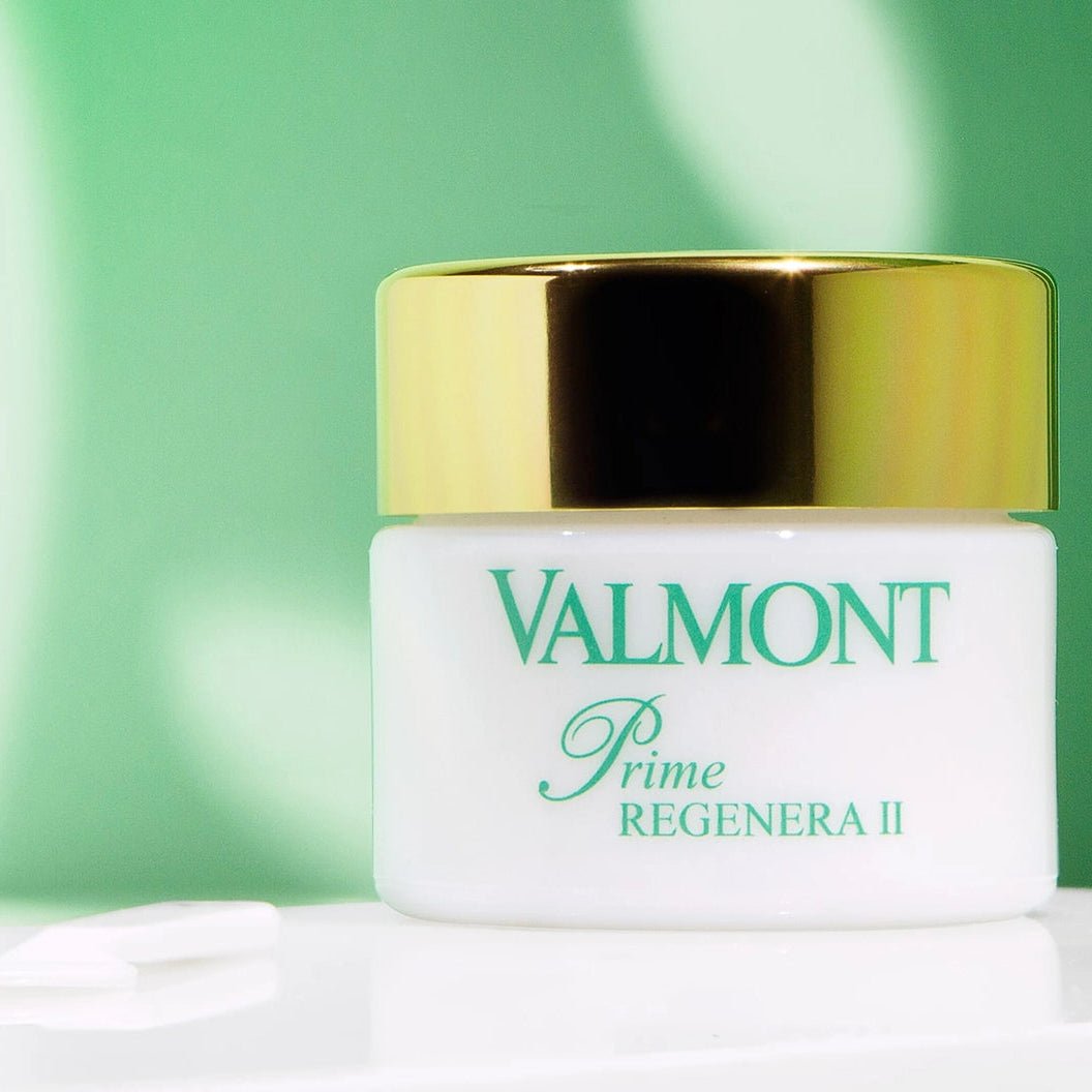 Valmont skincare product with gold lid on a green background