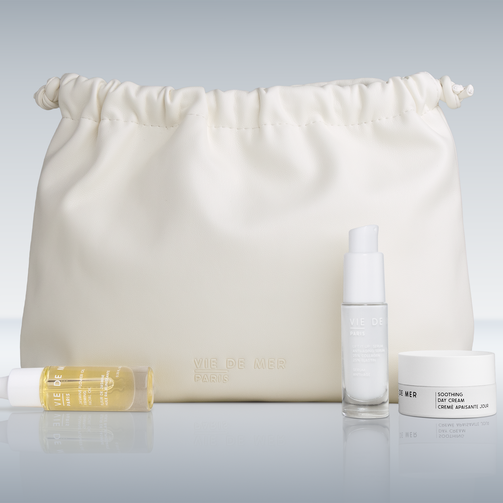 Skincare products including a bottle, jar, and roller on a white background with a drawstring bag.