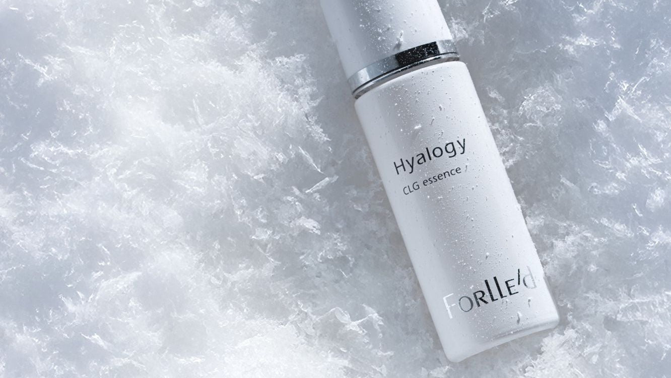Skincare bottle labeled 'Hyalogy' on a textured white background