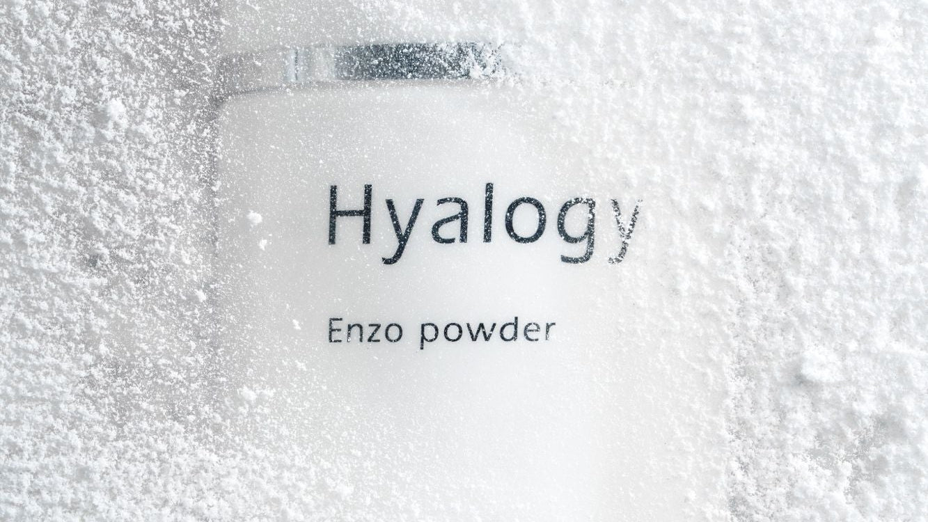 Jar of Hyalogy Enzo powder on a textured white background