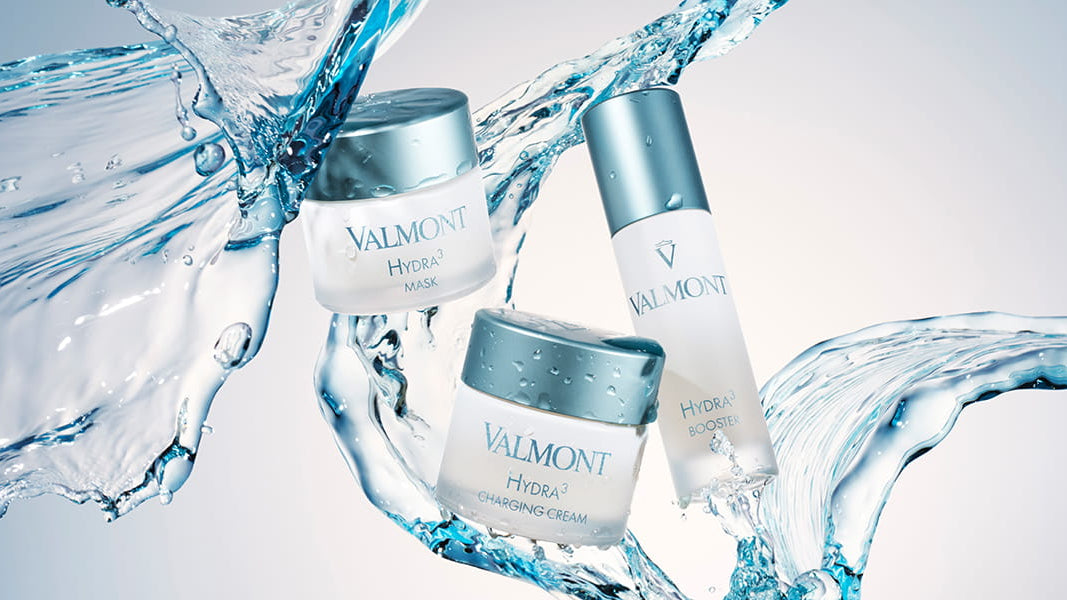 Valmont skincare products with water droplets on a light blue background