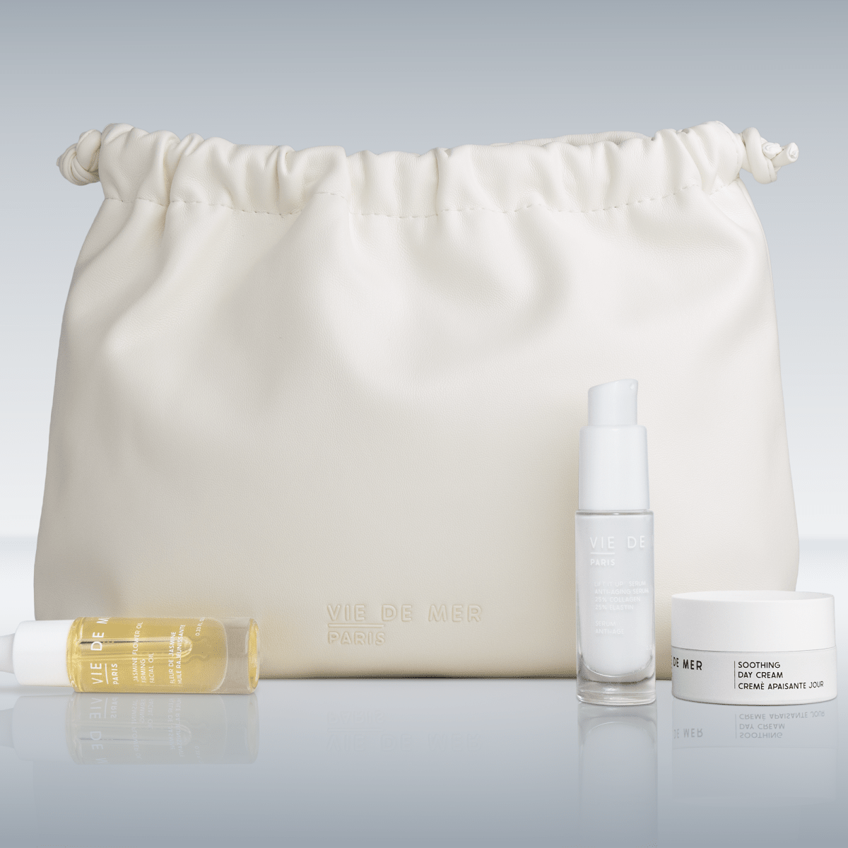 Skincare products including a bottle, jar, and roller on a white background with a drawstring bag.